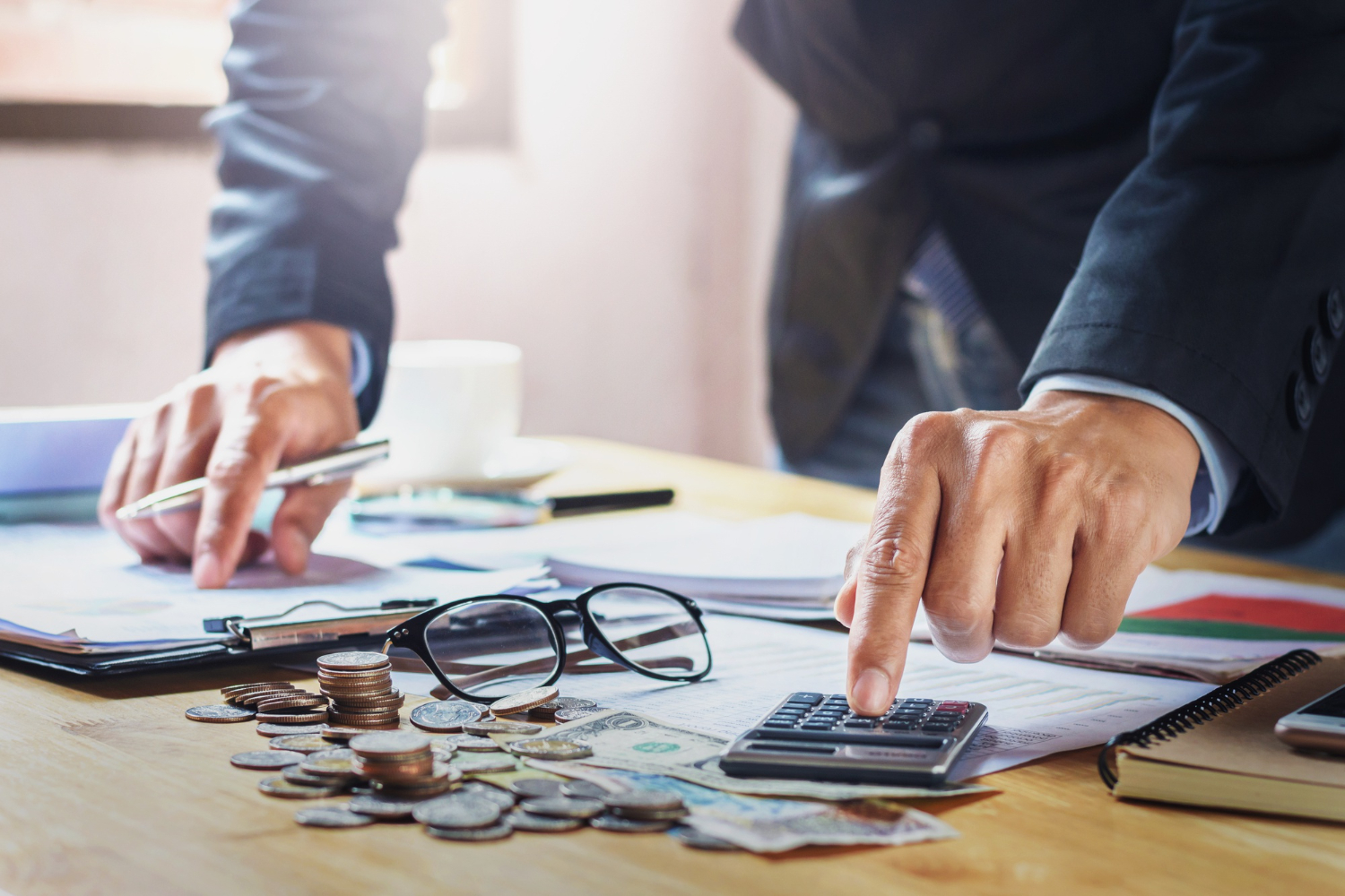 pessoas fazendo calculos em referência à pendencia fiscal