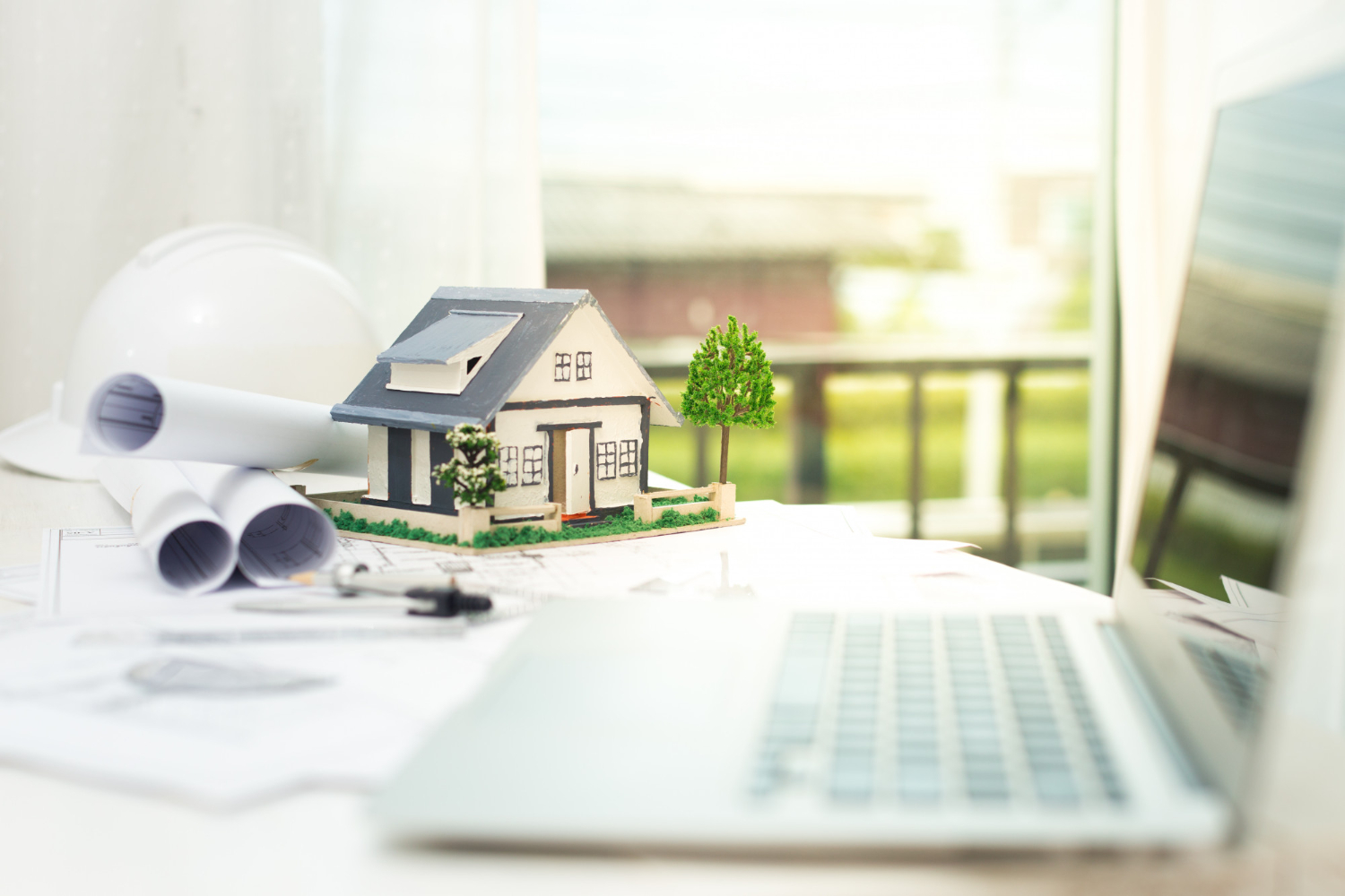 usucapiao: maquete de casa, notebook e papéis